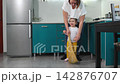 Young Caucasian teacher demonstrates sweeping to a little girl during a kindergarten lesson. The Montessori educational activity develops coordination, attention, responsibility, and practical abiliti 142876707
