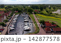 Wide horizontal aerial drone video of historic harbor marina, yachts, traditional windmill, red roof houses, and countryside moat in Veere, Zeeland, Netherlands on sunny afternoon 142877578