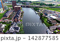 Wide horizontal aerial drone video of urban canal, modern apartment blocks, houseboats, highway bridge, and residential neighborhood in Leiden, South Holland, Netherlands on sunny afternoon 142877585