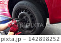 自動車のタイヤ交換をする整備士の手 142898252