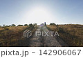 Woman trail running solitary across rural steppe forward tracking shot 142906067