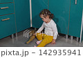 Preschool educator teaches a little girl to clean the floor independently in a kindergarten classroom. The activity reflects Montessori principles and supports motor development. Top view 142935941