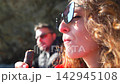Woman chocolate eating while relaxing outdoors and drinking from a red polka dot cup during a sunny day trip 142945108
