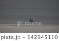 Cargo ship ocean sailing across vast dark water at twilight, commercial transport concept. 142945110