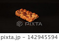 Chef Hands Adjusting Fresh Pecan Maple Danish Pastry on Black Surface 142945594