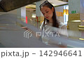 Young attractive woman riding an escalator downstairs 142946641