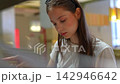 Young woman placing an order at a self service kiosk 142946642