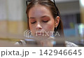 Young bored student closing her eyes at the library 142946645
