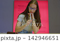 Thoughtful young woman with glasses signing a document 142946651