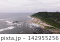 夏の千葉県、岩礁が広がる海岸と岬、浜沿いの集落と緑の丘を望むドローン空撮 142955256