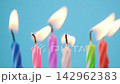 Birthday candles burning with glowing flames against a blue background. Slow motion 142962383