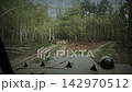 Driving a military vehicle on a dirt road through a spring forest slow motion Driving a military vehicle on a dirt road through a spring forest slow motion 142970512
