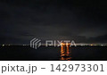 一段展現寧靜夜晚海灣地區和遠處城市燈光的視頻，水面上閃爍著燈光，夜空漆黑一片。 142973301