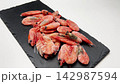 Side view close-up of pink frozen shrimps on a white background on a blackboard, the camera moves smoothly along. Seafood concept, seafood cooking. High quality 4k footage 142987594