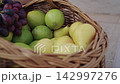 Picking fresh fruit from a basket in an outdoor setting 142997276