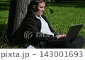 Young attractive caucasian sitting at the city park and working on his laptop computer. 143001693