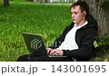 Young attractive caucasian sitting at the city park and working on his laptop computer. 143001695