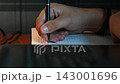 Hands writing in a notebook. Close-up. 143001696