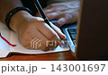 Hands writing in a notebook. Close-up. 143001697
