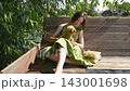 girl petting a small dog on her lap. Young girl with small attentive dog, teenager sitting maltipoo on bench. 143001698