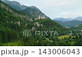 Experience the majestic Neuschwanstein Castle as morning sunlight bathes the Bavarian landscape. Discover the stunning scenery surrounding this fairytale chateau and its lush green hills. 143006043