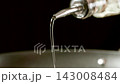 MACRO: Stream of olive oil pouring from a bottle to a cooking pan, Slow motion 143008484