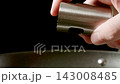 Man hand sprays vegetable oil from dispenser 143008485