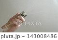 BOTTOM VIEW: Man hand sprays vegetable oil from dispenser (spray gun) on a frying pan 143008486
