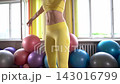 Fitness routine featuring core exercises in a bright studio with colorful exercise balls 143016799