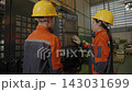 The engineer works in the factory, inspecting equipment at the service center that comes out of the machinery. 143031699
