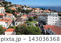 Panoramic view of colorful hillside houses, lush gardens under a bright blue sky in Funchal, Madeira, Portugal. 143036368