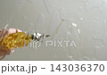 BOTTOM VIEW: Close shot of pouring oil from a bottle to a cooking pan, Slow motion 143036370