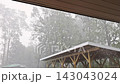 Rain pours down heavily on wooden shed near forest sky is dark cloudy during thunder storm 143043024