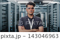 Network Engineer Standing in Data Center Server Rack Corridor 143046963