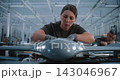 Young Female Worker Assembling Drone Components at Advanced Aerospace Manufacturing Workbench 143046967