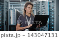 Female Network Engineer Configuring Server Hardware on Laptop 143047131