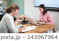Focused middle-aged man and woman working with laptops and papers during workday in office 143067964