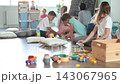 Children playing with toys sitting on floor in kindergarten 143067965