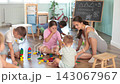 Happy children of different ages playing with wooden toys inside development center playroom 143067967