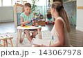 Interested little boy playing with wooden toy train during psychological assessment at development center 143067978