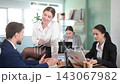 Young female employee of the company flirts with a male employee while sitting on a table  143067982