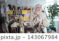 Elderly woman tries on fur coat in clothing store 143067984