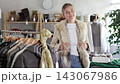 Woman try on fur jacket in front of mirror 143067986