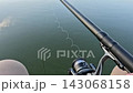 Hands Adjusting Fishing Rod Reel in Close-Up Outdoor Shot 143068158