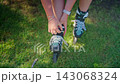 A Young Skater Prepares for Fun in the Sun: Lace Tightening and Relaxing on a Bench After Roller Skating Adventures 143068324