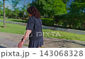 Capturing a Journey: A Person Walking Through a Lush Green Park Pathway on a Bright Sunny Day, Surrounded by Nature's Vibrant Beauty and Serenity 143068328