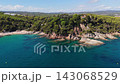 An aerial view of a drone flies over the beach, sea and coastal cliffs near Santa Clotilde Park on a sunny day in the tourist town of Lloret de Mar, Catalonia, Spain 143068529