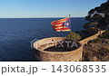 The flag of Catalonia flies on the tower of a fortress on the seashore at sunset on a sunny day in the tourist town of Tossa De Mar, Catalonia, Spain 143068535