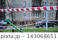 Red and white striped barrier tape blocking access to a restricted outdoor playground 143068651
