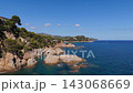 An aerial view of a drone flies over the beach, sea and coastal cliffs near Santa Clotilde Park on a sunny day in the tourist town of Lloret de Mar, Catalonia, Spain 143068669